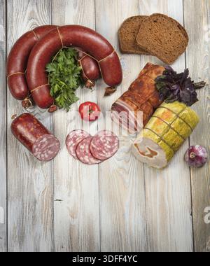 Verschiedene Arten von Würsten mit Gemüse auf einem Holztisch Stockfoto