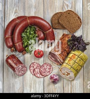 Verschiedene Arten von Würsten mit Gemüse auf einem Holztisch Stockfoto