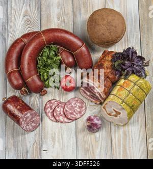 Verschiedene Arten von Würsten mit Gemüse auf einem Holztisch Stockfoto