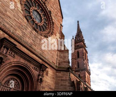 Gotische Kathedrale mit verziertem Turm und Rosenfenster vor bewölktem Himmel. Stockfoto