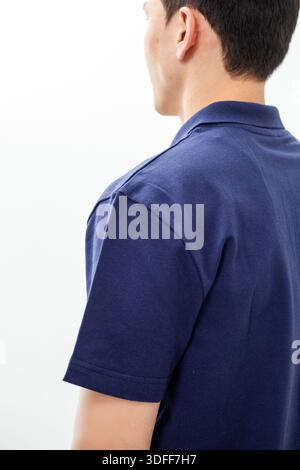 Seitenansicht eines Mannes in marineblauem Poloshirt auf weißem Hintergrund. Stockfoto