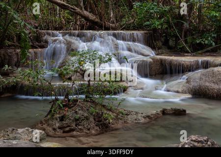 Gestufter Wasserfall, der über Felsen im Erawan-Nationalpark, Thailand, stürzt. Üppiger tropischer Wald umgibt den klaren Wasserstrom. Stockfoto