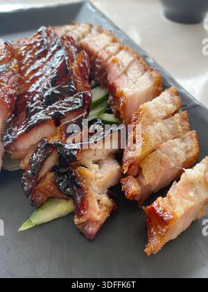 Nahaufnahme von geröstetem knusprigem Schweinebauch und Saibling siew Barbecue Schweinefleisch. Beliebte asiatische Hawker-Küche und Restaurantküche, reichhaltige, herzhafte und appetitliche Mahlzeiten Stockfoto