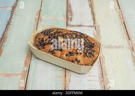 Ein hoher, flauschiger, tiefbrauner Schokoladenschwamm, bedeckt mit einer glänzenden Schokoladenglasur und verziert mit dunklen und weißen Schokoladenspänen in einem Elegan Stockfoto
