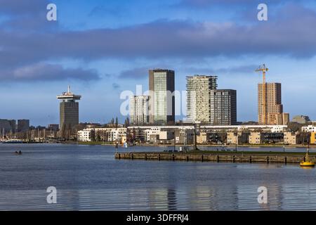 Blick auf die Skyline von Amsterdam Noord über den IJ-Fluss mit dem A'DAM-Turm und modernen Wohnhäusern an einem sonnigen Tag. Amsterdam Ne Stockfoto