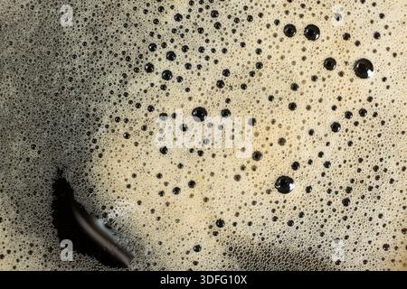 Makrostruktur aus goldenem Kaffeeschaum mit vielen kleinen Blasen Stockfoto