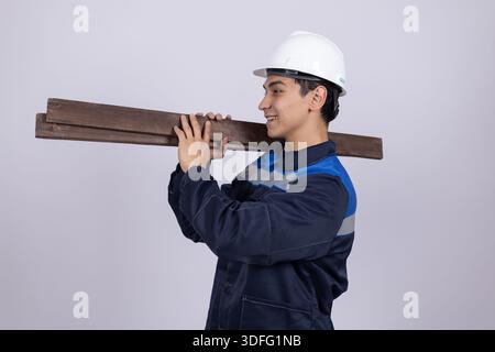 Bauarbeiter mit schwerem Holz auf der Schulter Stockfoto