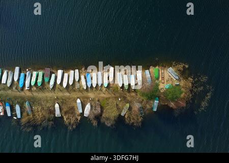 Aus der Vogelperspektive sehen Sie kleine Boote, die am Ufer des Flusses entlang der Küste gezogen und angeordnet wurden. Stockfoto