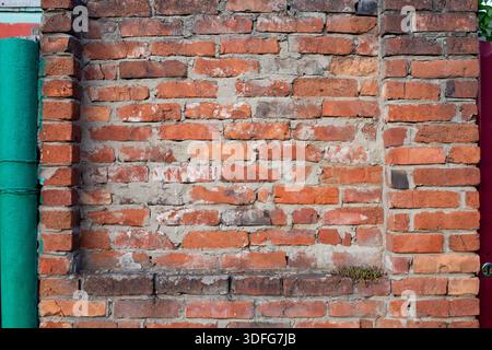 Roter alter Backsteinmauerhintergrund, Backsteinmauerstruktur. Alte, zerstörte rote Mauer, Hintergrund mit Textur alter roter Mauer und Putzelemente. Stockfoto