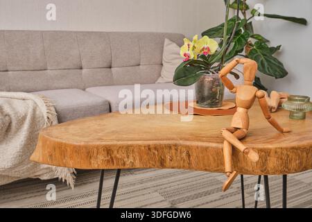 Hölzerne Kunstpuppe auf einem rustikalen Wohnzimmertisch Stockfoto