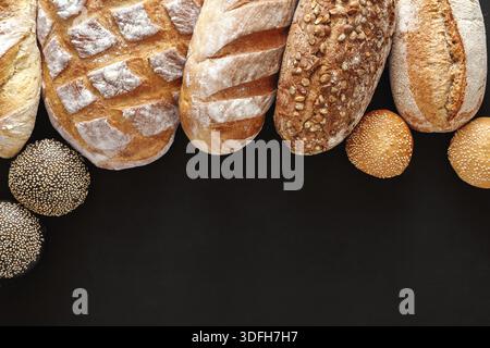 Frisch gebackenes Brotsortiment auf schwarzer Oberfläche Stockfoto