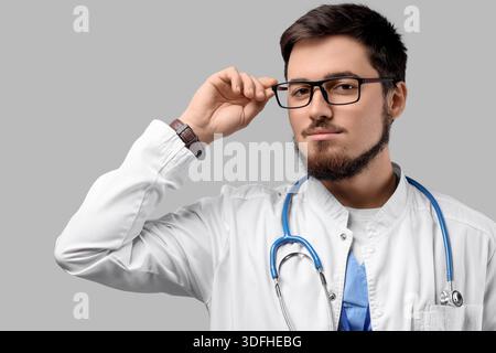 Porträt eines gutaussehenden Arztes in Brille auf hellem Hintergrund Stockfoto