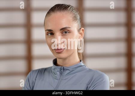 Porträt einer jungen Frau, die zuversichtlich in Innenräumen lächelt Stockfoto