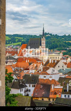 Die Veitskirche steht hoch unter den Dächern von Cesky Krumlov. Der Blick fängt die Gebäude der Stadt und die Landschaft im Sommer ein. Diese Szene zeigt tschechische Architektur und Natur. Stockfoto