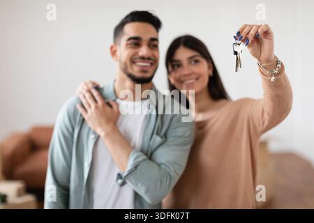 Glückliches Paar zeigt Schlüssel ihrer Wohnung, selektiver Fokus Stockfoto
