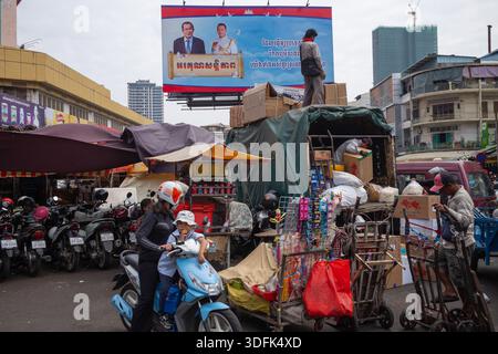 Ein Plakat mit einem Poster des ehemaligen kambodschanischen Premierministers Hun Sen und des aktuellen Premierministers Hun Manet, das auf dem Orussey Market zu sehen ist. Stockfoto