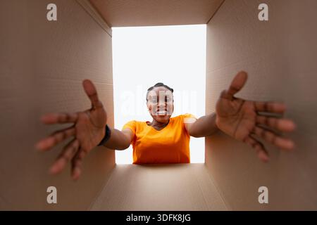 Glückliche schwarze Frau Auspacken Papppaket, Empfang Online-Lieferung, Ansicht von unten Stockfoto