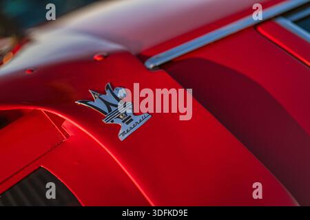 Imola, italien 01. januar 2026: maserati Trident-Emblem auf roter klassischer Sportwagenhaube, Nahaufnahme mit italienischem Design, Tradition, Chrom-Ref Stockfoto