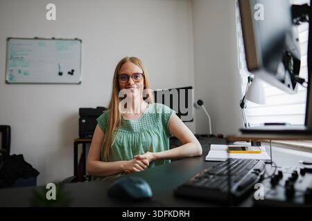 Lächelnder Profi in einem gemütlichen Büro an einem hellen Arbeitstag Stockfoto