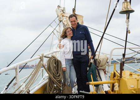 Vater und Tochter stehen zusammen auf dem Deck eines traditionellen Segelschiffes, umgeben von Seilen und maritimer Ausrüstung Stockfoto