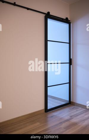 Minimaler Innenraum mit moderner Glasschiebetür und schwarzem Rahmen, leerem Wandhintergrund mit Kopierraum. Stockfoto