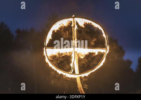 Brennendes Symbol der Sonne, ein Sonnenkreuz oder Sonnenrad bei heidnischer Nachstellung der Kupala-Nacht, in Polen Noc Kupaly genannt. Slawischer Feiertag wird gefeiert Stockfoto
