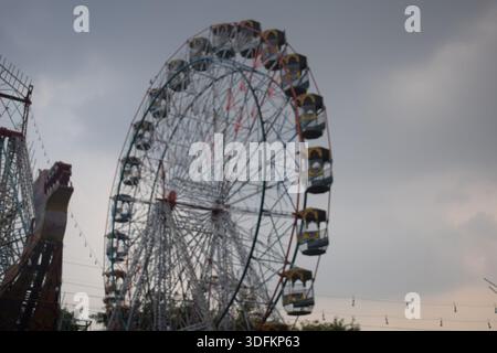 Nahaufnahme des mehrfarbigen Riesenrads während Dussehra Mela in Delhi, Indien. Unteransicht des Riesenradschwenkens. Riesenrad mit farbenfrohen Kabinen durin Stockfoto