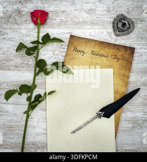 Antike Vorratstitelungen mit handgeschriebenen Happy Valentines Day, herausragen aus dem Buch, rote Rose, detaillierte silberne Kiel stehen in Form von hart, verziert Stockfoto
