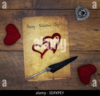 Antike Vorratstitelei mit geschriebenem Happy Valentines Day, 2 rote Kuschelherzen, bemalte Herzen, detailreicher silberner Kiel-Ständer in Form von hart, verzierte si Stockfoto