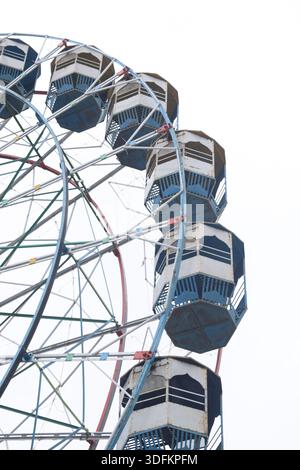 Nahaufnahme des mehrfarbigen Riesenrads während Dussehra Mela in Delhi, Indien. Unteransicht des Riesenradschwenkens. Riesenrad mit farbenfrohen Kabinen durin Stockfoto