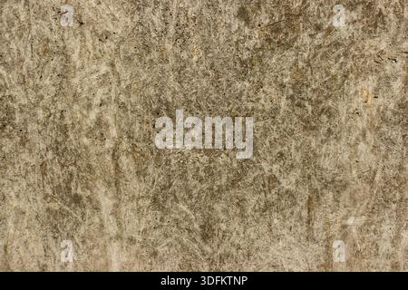 Gealterte Betonwand mit gelben und braunen Verfärbungen, mit rauer Textur und natürlichen Witterungsmustern Stockfoto