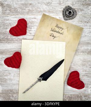 Antike Vorratstitelungen mit handgeschriebenen Happy Valentines Day, herausragen aus dem Buch, 3 rote Kuschelherz, detaillierte silberne Kiel stehen in Form von hart, o Stockfoto