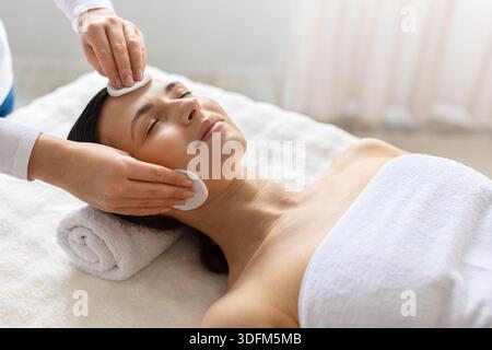 Kosmetologe Arzt reinigt das Gesicht einer jungen Frau im Spa mit Wattepads Stockfoto