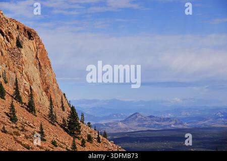 Felsige Klippen und Talushänge über Nadelwäldern mit Panoramablick auf die Berge, vom Pikes Peak Highway in der Nähe von Colorado Springs, Colorado, USA. Stockfoto