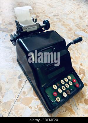 Klassischer mechanischer Rechner, mit dem grundlegende arithmetische Berechnungen durchgeführt und die Ergebnisse auf eine Rolle Papier gedruckt werden. Mechanische Nachfügemaschine. Stockfoto