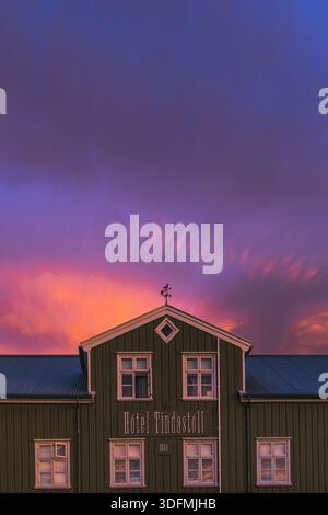 Blick auf das Hotel Tindastoll unter einem lebendigen Sonnenuntergangshimmel, der mit violetten und orangen Tönen gemalt ist und eine magische Atmosphäre schafft, Saudarkrokur, Skagafjordur, Stockfoto