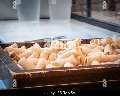 Frische hausgemachte italienische Rigatoni-Nudeln auf Holztablett Stockfoto