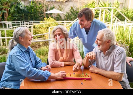 Senioren spielen im Freien ein Spiel mit einem Physiotherapeuten in einem Reha-Zentrum, das sich auf Rehabilitation und Erholung nach Verletzungen oder Operationen konzentriert. Th Stockfoto