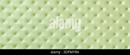 Pastellgrüne Lederstruktur mit Capitone-Muster, Makrohintergrund aus olivfarbenem Retro Chesterfield Vintage-Textilgewebe. Stockfoto
