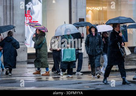 London, Großbritannien. Januar 2026. Die Leute überqueren die Kreuzung am Oxford Circus - nass, ob im West End von London einkaufen. Guy Bell/Alamy Live News Stockfoto