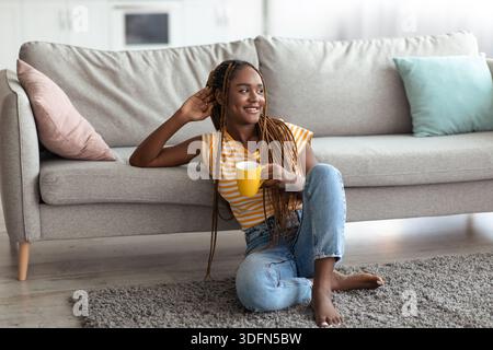 Glückliche afroamerikanerin, die ein Wochenende zu Hause genießt Stockfoto