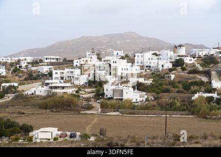Blick auf weiß getünchte Häuser und Windmühlen an einem zerklüfteten Hügel, in sanftem Licht getaucht, schaffen eine zeitlose Szene griechischer Architektur, Ano Stockfoto