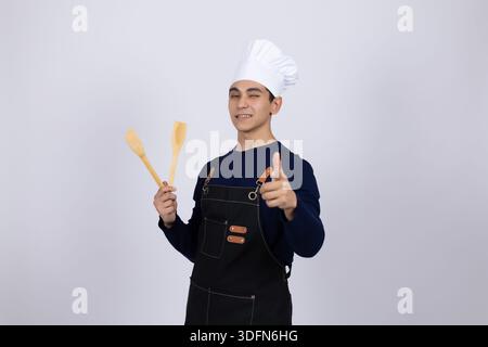 Glücklicher Koch mit Holzlöffeln Stockfoto