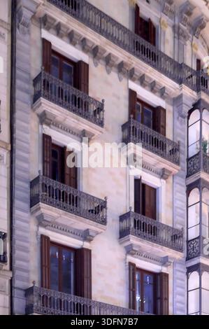 Detail einer eleganten Fassade mit schmiedeeisernen Balkonen und Holzläden in einem historischen Gebäude. Stockfoto