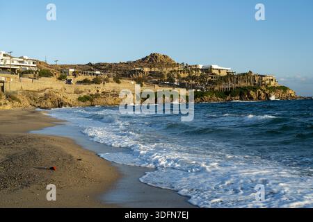 Blick auf das türkisfarbene Wasser des Meeres, das den Sandstrand küsst, während die Architektur auf der zerklüfteten Küste liegt und Natur und menschliche Präsenz miteinander verbindet; Stockfoto