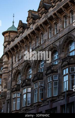 Ein detaillierter Blick auf die Steinfassade eines mehrstöckigen Hilton-Hotelgebäudes mit Bogenfenstern und kunstvollen architektonischen Details in Edinburgh, S. Stockfoto