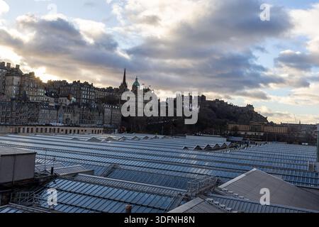 Ein Blick auf die Stadt mit einer dichten Ansammlung von alten Steinbauten auf einem Hügel unter einem bewölkten Himmel, mit einem Vordergrund, der von einer riesigen Fläche von gl dominiert wird Stockfoto