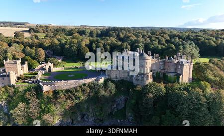 Weite Luftsicht auf Culzean Castle und das umliegende Anwesen, dramatisch über bewaldeten Klippen an der Küste von Ayrshire mit Blick auf den Firth gelegen Stockfoto