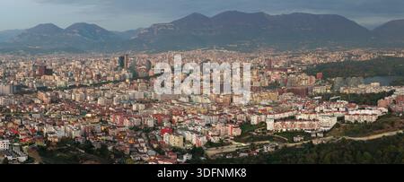 Ein warmer Panoramablick bei Sonnenuntergang über die dichte Skyline von Tirana und die modernen Hochhäuser. Stockfoto