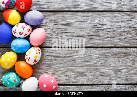 Farbenfrohe dekorierte Eier auf Holztisch für festliche Feierlichkeiten Stockfoto